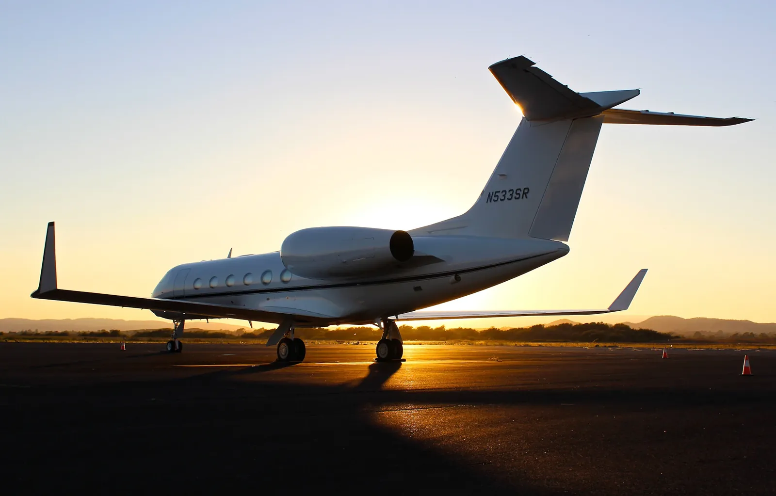 A private jet parked on the tarmac at golden hour