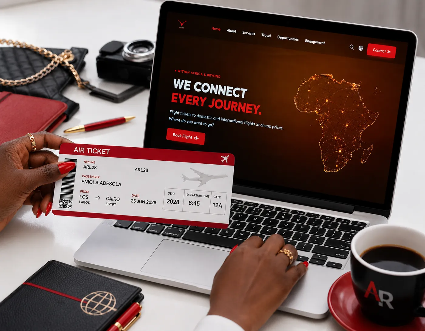 A boarding pass, passport and camera on a desk beside a laptop